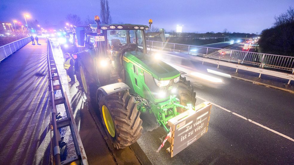 Leuchtender Protest: Bauern stehen am Freitag vergangener Woche mit Traktoren auf einer Brücke über der Autobahn A2 bei Garbsen in der Region Hannover. Foto: Stratenschulte/DPA