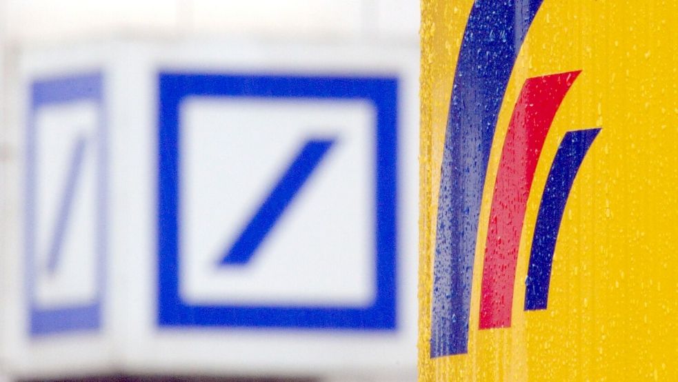 Das Logo der Deutschen Bank hängt gegenüber dem Logo der Postbank. Beide konnten ihre Filialen am Montagmorgen nicht öffnen. Foto: Gambarini/dpa