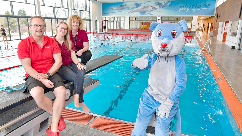 Holger van der Slyk (von links), verantwortlich für die Schwimmschule sowie die Geschäftsführerinnen Lisa Kesse und Anja Buse freuen sich mit dem Maskottchen Pietje über das fünfjährige Bestehen. Foto: Ortgies