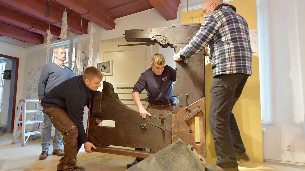 Schwer zu schleppen hatten die Tischlerei-Mitarbeiter. Museumsleiter Oliver Freise (links) schaut aufmerksam zu. Foto: Ortgies