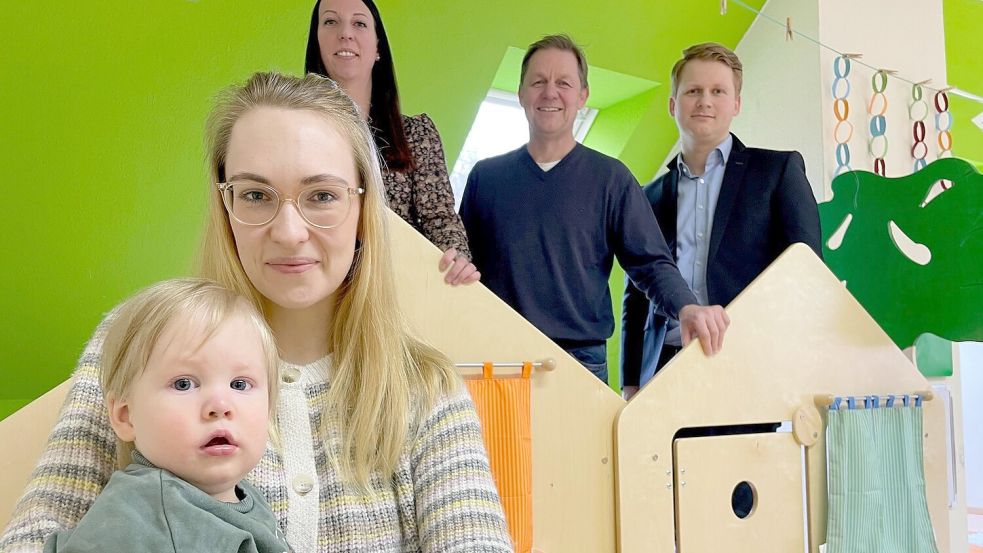 Baby Arne mit seiner Mutter Julia Peters suchen einen Krippenplatz. Kita-Leiterin Natalie Broers, Ralf Möhlmann (Jümme) und Frederick Engel (Landkreis) hätten gern eine Lösung. Foto: Nording