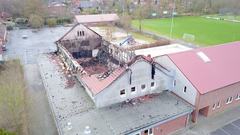 Das Dach der Sporthalle in Neermoor ist durch das Feuer eingestürzt. Das anliegende Vereinsheim des SV Concordia Neermoor ist durch den Brand stark in Mitleidenschaft gezogen worden. Foto: Loger