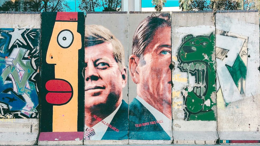 Ein Graffiti auf Überresten der Berliner Mauer zeigt die ehemaligen US-Präsidenten und Aushängeschilder der westlichen Demokratie John F. Kennedy (l) und Ronald Reagan. Aber sichert Demokratie auch den Frieden? Foto: Unsplash/Isai Ramos