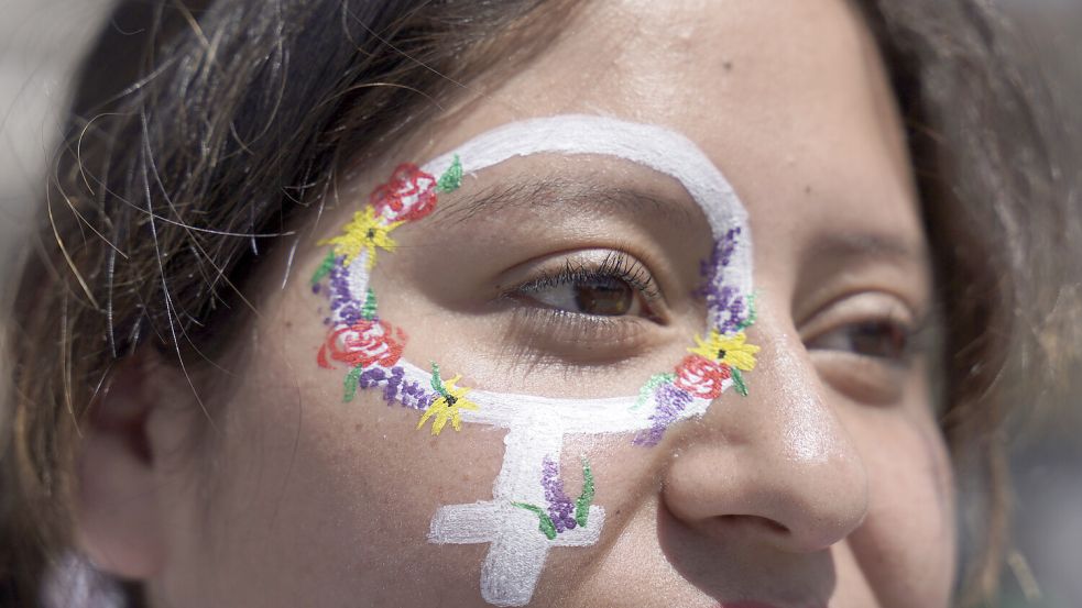 Eine Frau hat sich für eine Demo in Mexiko anlässlich des Weltfrauentags 2023 das international geltende Symbol für Frauen auf die Wange gemalt. Am 8. März gibt es weltweit Veranstaltung von, mit und für Frauen - auch in Emden. Symbolfoto: Aurea del Rosario/AP
