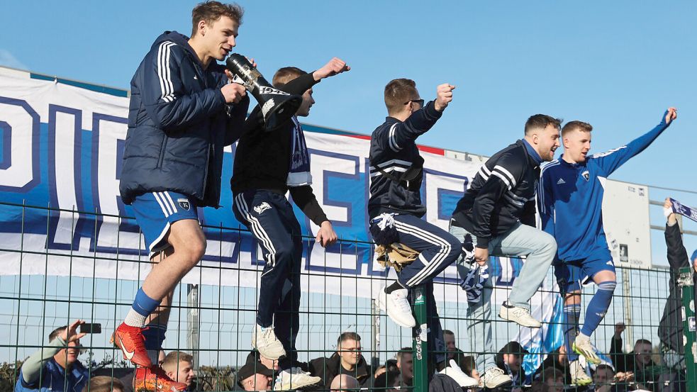 David Schiller (links) gab wieder einmal den „Humba“-Anstimmer. Tobias Steffen (rechts) kletterte als Mann des Tages ebenso auf den Zaun des Gästeblocks. Fotos: Doden, Emden