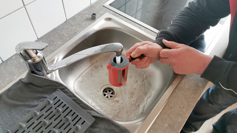 Mit einem Wasserbecher wird der Verbrauch an Litern pro Minute gemessen. Foto: Terhorst