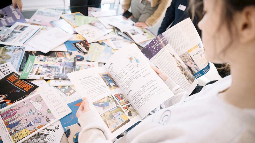 Auf der Preisverleihung hatten die Schüler aus Mittegroßefehn die Möglichkeit, in den Zeitungen der Konkurrenz zu blättern. Foto: Victor Hedwig/JPN