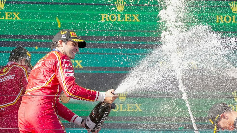 Ferrari-Pilot Carlos Sainz feiert mit Champagner seinen Sieg. Foto: Scott Barbour/AP/dpa
