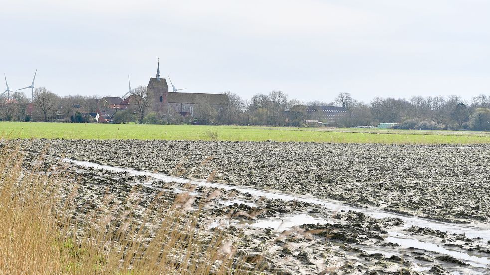Ein nasses Feld mit Blick auf Groothusen in der Krummhörn. Foto: Wagenaar
