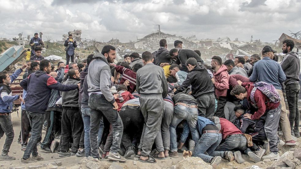 Menschen drängen sich um Pakete mit humanitärer Hilfe, die über dem nördlichen Gazastreifen abgeworfen wurden. Israel hat „sofortige Schritte“ zur Erhöhung humanitärer Hilfe für die Zivilbevölkerung beschlossen. Foto: Mahmoud Issa/dpa