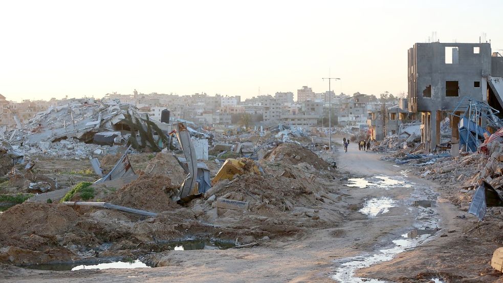 Menschen gehen an Trümmern und Ruinen auf einer Straße im Flüchtlingslager Al-Maghazi im Zentrum des Gazastreifens vorbei. Foto: -/XinHua/dpa