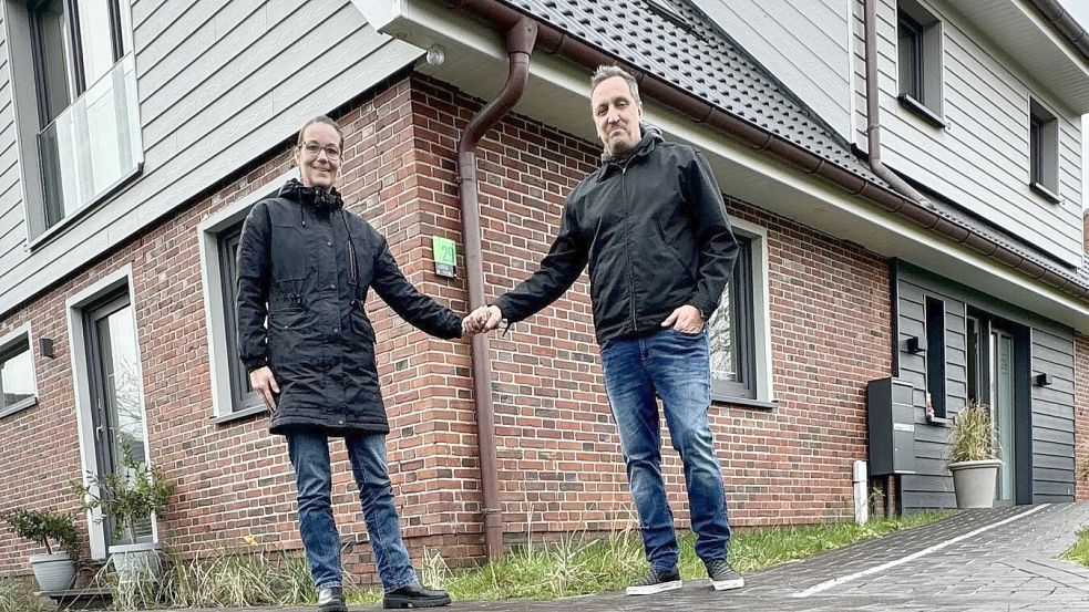 Petra Moselage und ihr Mann Andreas vor ihrem komplett sanierten Haus auf Langeoog. Zwischen ihnen die Grüne Hausnummer. Foto: Moselage