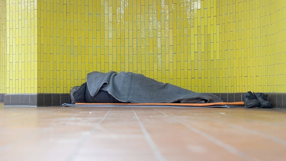 Ein Obdachloser liegt in seinem Schlafsack in einer U-Bahnstation in der Hamburger Innenstadt. 17,7 Millionen Menschen waren 2023 in Deutschland von Armut oder Ausgrenzung bedroht. Foto: Marcus Brandt/dpa