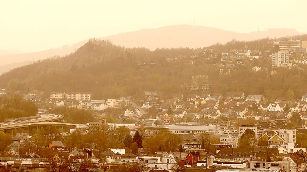 Hüttental in Siegen: Saharastaub verfärbt den Himmel gelb-rötlich und trübt die Sicht ein. Die kleinen Sandkörner können auch in die Lunge gelangen. Foto: IMAGO/Rene Traut