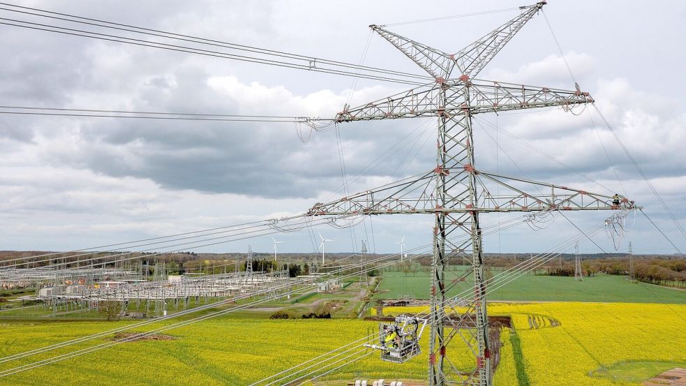 An neuen Strommasten nahe des Umspannwerkes Conneforde in Niedersachsen finden Bauarbeiten statt. Foto: Sina Schuldt/dpa