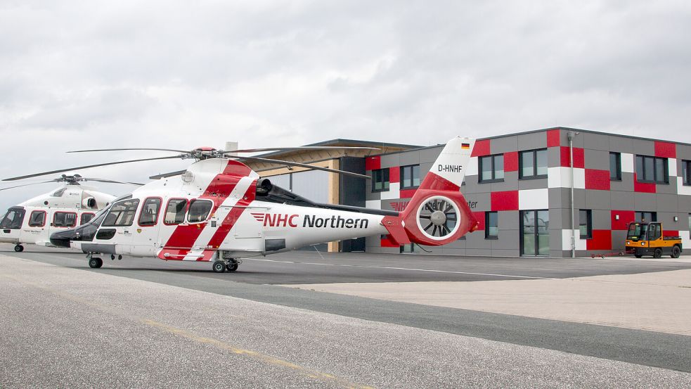 Zwei Hubschrauber des Unternehmens Northern Helicopter (NHC) stehen vor dem Gebäude der neuen Rettungsstation auf dem Flugplatz in Norddeich. Die Reederei Norden-Frisia hat sie bauen lassen. Foto: DPA