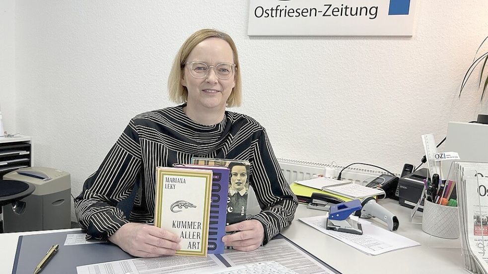 Esther Saathoff sitzt auf ihrem Arbeitsplatz im OZ-Media-Store in Emden. In ihrer Hand ihre Lieblingsbücher. Ganz vorne: „Kummer aller Art“ von Mariana Leky. Foto: Weiden