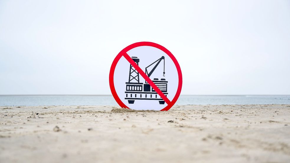 Ein Plakat gegen die geplante Erdgasförderung steht am Strand auf Borkum. Ein Konsortium um das niederländische Unternehmen One-Dyas plant, von Ende 2024 an Erdgas vor den Inseln Borkum und Schiermonnikoog zu fördern. Foto: Schuldt/DPA