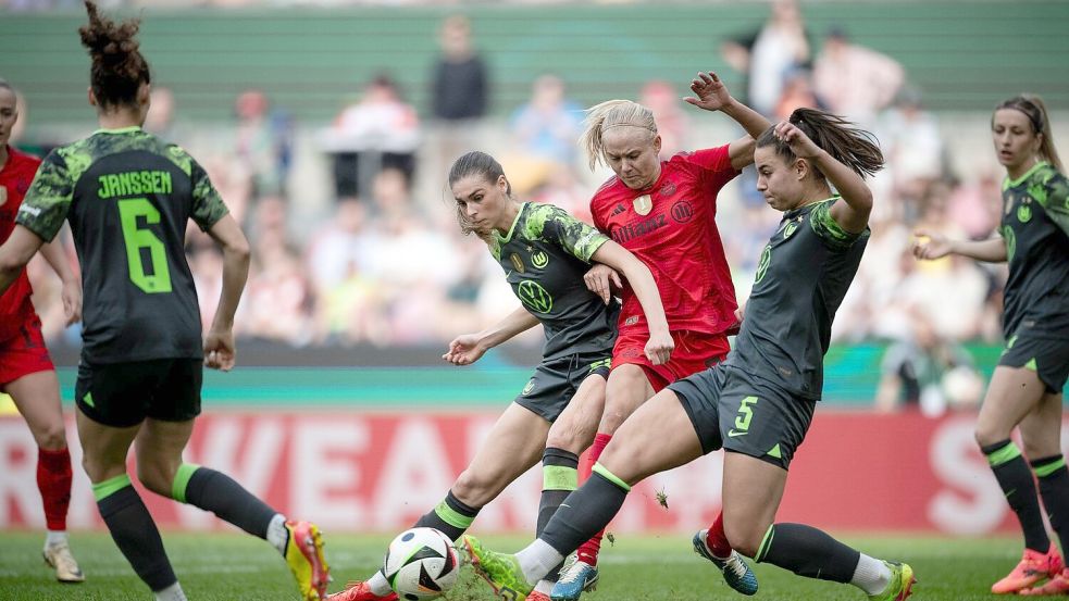 Wolfsburgs Jule Brand (l) und Lena Oberdorf kämpfen mit Bayerns Pernille Harder um den Ball. Foto: Fabian Strauch/dpa