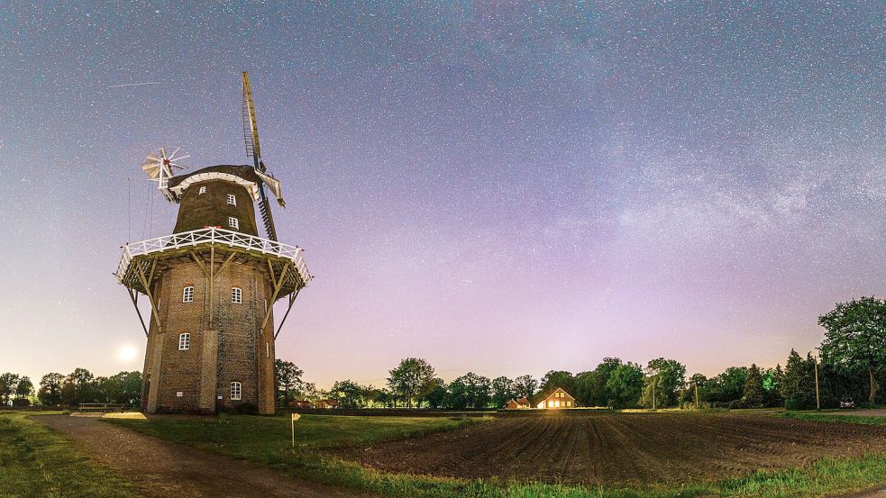 Das Nordlicht ist nur noch schwach, aber dafür mit Milchstraße bei der Holtlander Mühle: ein Farbenspiel am Horizont. Die Mühle wird gerade noch so vom Mondlicht angeleuchtet und umliegende Bäume werfen ihre langen Schatten aufs Feld und den Fuß der Mühle, schreibt der Fotograf. Foto: Yorick Krauth