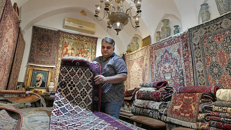 Ein iranischer Teppichhändler arbeitet in seinem Geschäft auf dem traditionellen Basar der Stadt Kashan. Foto: Vahid Salemi/AP/dpa
