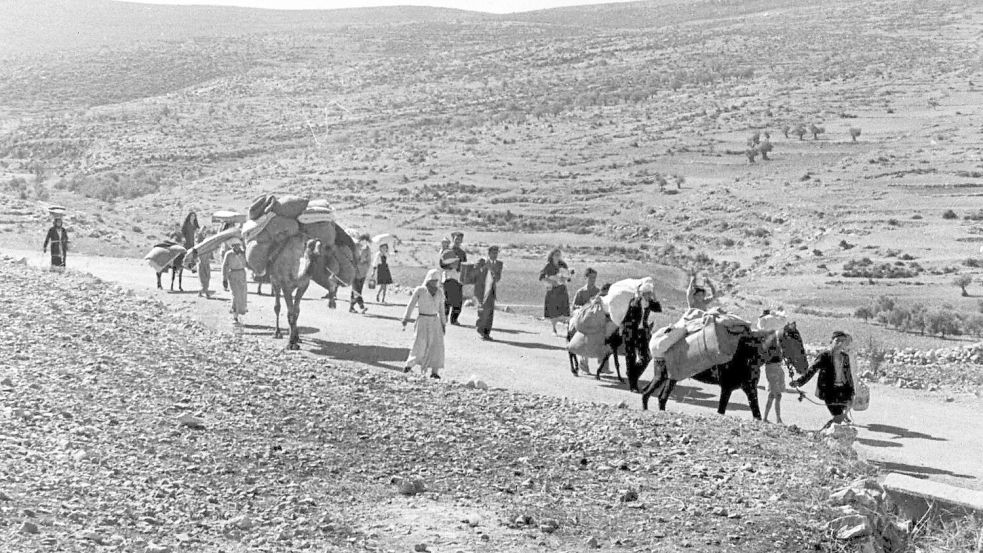 Arabische Flüchtlinge gehen mit ihren Kindern und Habseligkeiten im Gepäck am 9. November 1948 auf einer staubigen Straße von Jerusalem in den Libanon. Die Staatsgründung Israels war 1948 für Hunderttausende von Palästinensern mit Vertreibung und dem Verlust von Heimat verbunden. Foto: Jim Pringle/AP/dpa