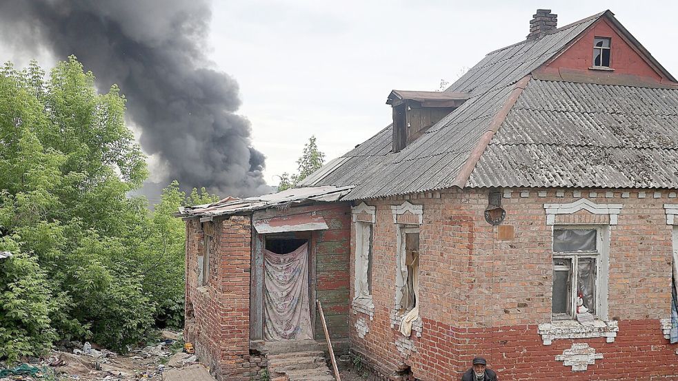 Nach dem Beschuss durch russische Truppen steigt hinter einem Haus in Charkiw eine Rauchsäule auf. Foto: -/ukrin/dpa