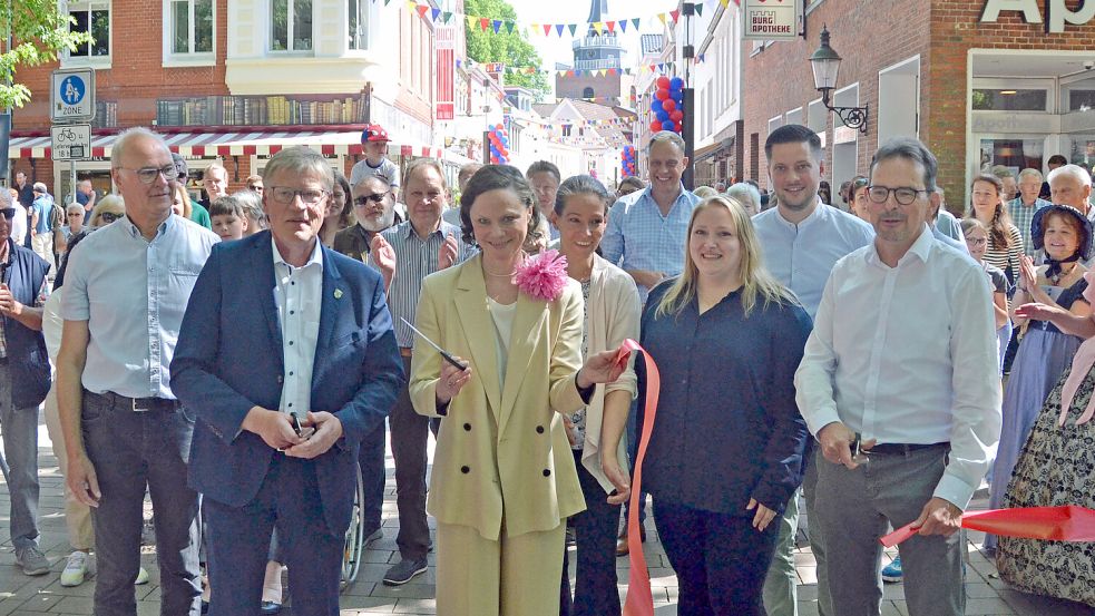 Bürgermeister Horst Feddermann, Heida Haltermann vom Kaufmännischen Verein und Hilko Kruse-Edenhuizen von der Baufirma Strabag (von links) durchschnitten das rote Band am Burgtor. Foto: Aiko Recke