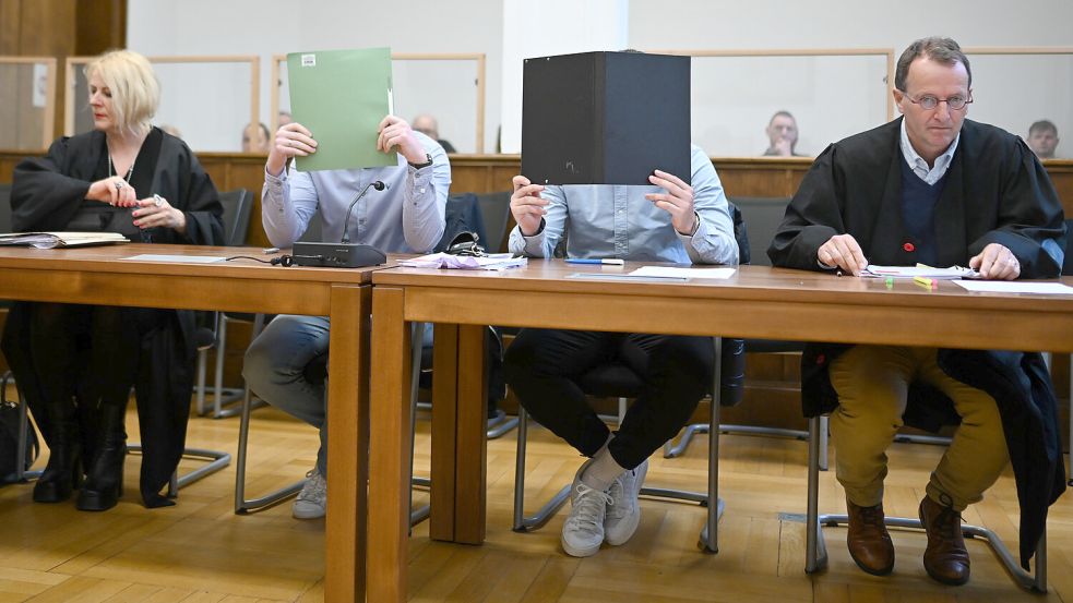Mit verdeckten Gesichtern sitzen die beiden Angeklagten neben ihren Verteidigern Tanja Brettschneider und Folkert Adler beim Auftakt des Prozesses in Aurich. Foto: DPA