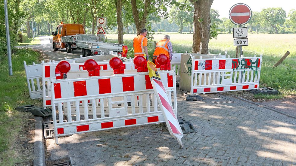Mitarbeiter des Auricher Betriebshofes stellten am Dienstag die Sperrung am Eckfehler Weg wieder auf. Foto: Romuald Banik