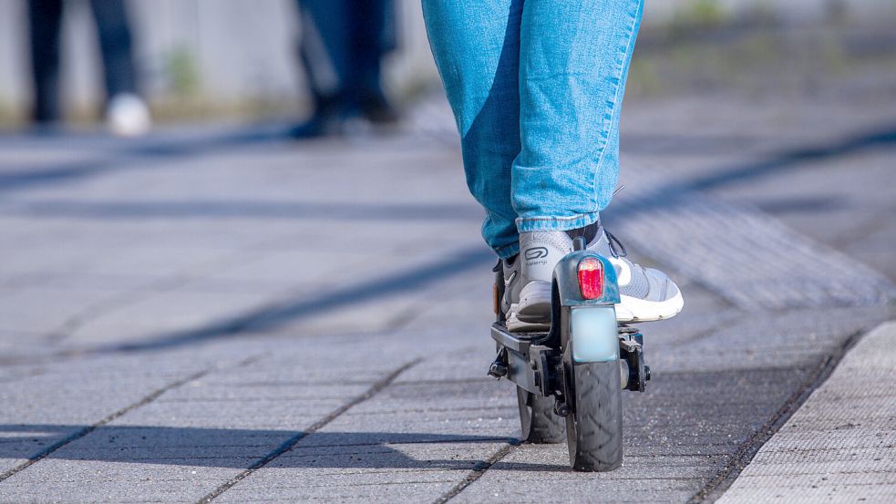 Ein Reisender fährt mit seinem E-Scooter über den Bahnsteig in Wismar. In den Bussen und Bahnen des VBN sind die E-Tretroller nun verboten. Foto: Büttner/DPA