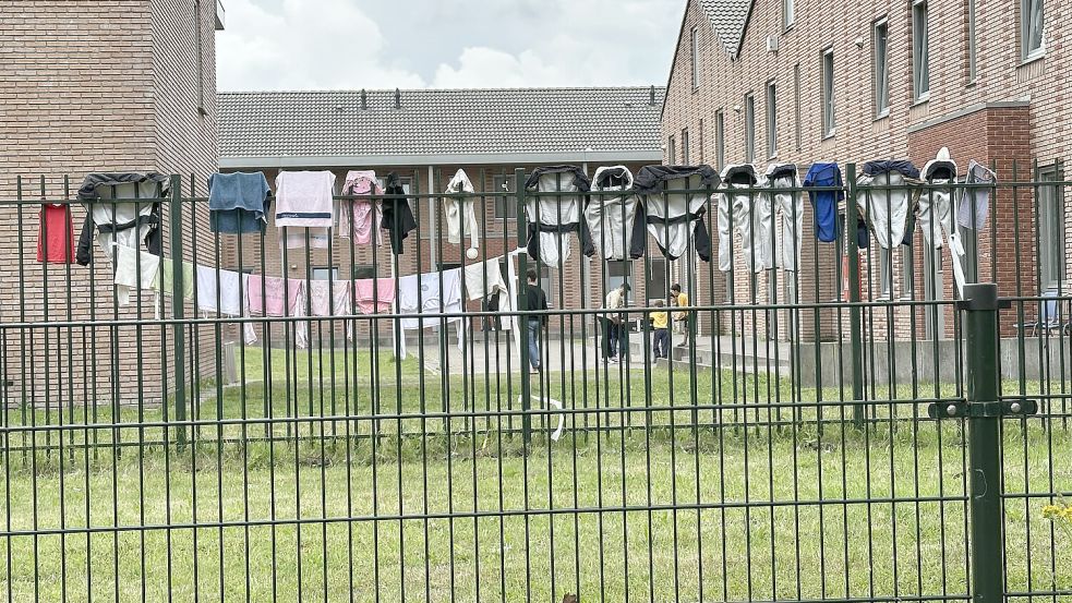 Blick durch den Zaun: Asylbewerber schlagen im Flüchtlingslager Ter Apel in den Niederlanden die Zeit tot. Foto: Dirk Fisser