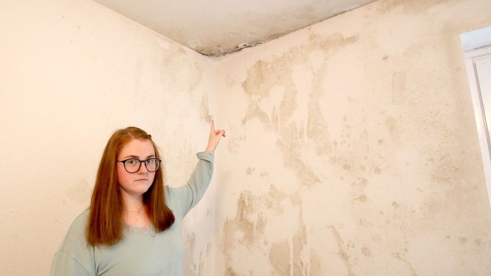 Lena Kruse aus Wiesmoor zeigt eine von Schimmel befallene Ecke in ihrer Mietwohnung. Foto: Böning