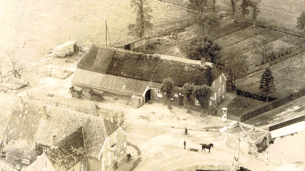 Ein Foto des ursprünglichen Compagniehauses in Ostgroßefehn. Zwischen Compagniehaus und dem Nachbargebäude, in dem sich eine Bäckerei befand, verläuft der Postweg. Am unteren rechten Rand des Bildes ist die Klappbrücke über den Großefehnkanal zu sehen. Foto: Archiv Habben