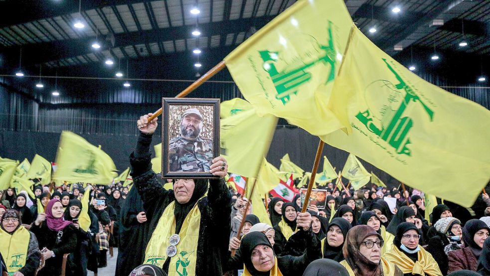 Anhänger der pro-iranischen Hisbollah-Partei nehmen im Libanon an einer Zeremonie zum Gedenken an den Tod von drei Hisbollah-Führern teil – zu sehen sind Flaggen mit dem militanten Logo der Hisbollah. Archivfoto: Naamani/dpa