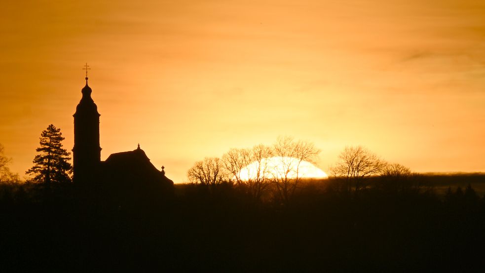 Impulse der Entschleunigung: Kirchturm im Sonnenaufgang Foto: dpa/396248206