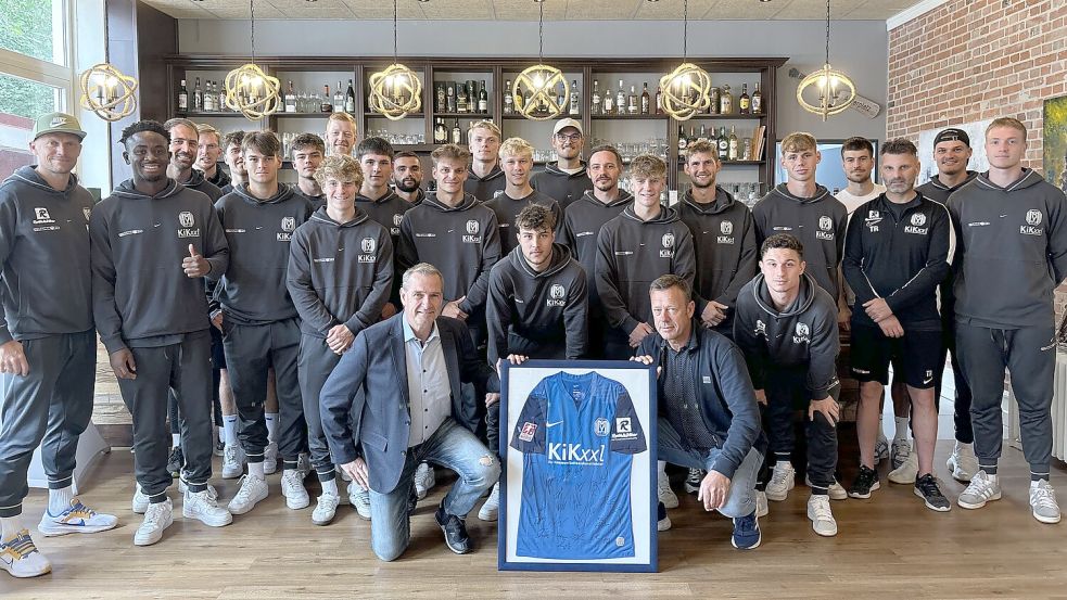 Die 1. Herrenmannschaft des SV Meppen an ihrem letzten Tag im Trainingslager in Westrhauderfehn mit ihrem mitgebrachten und von Frank Bohlmann gerahmten Gastgeschenk. Foto: Spindler