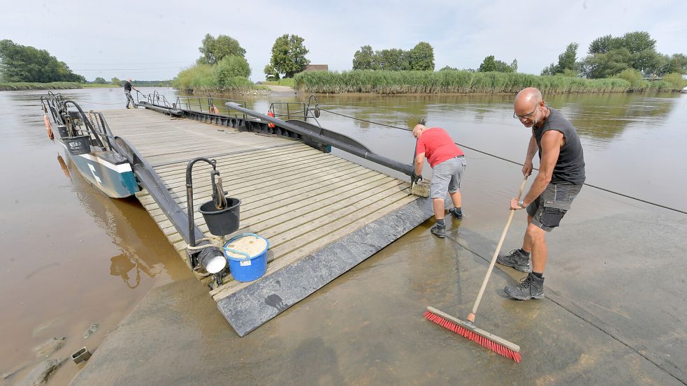 Wenn das Wasser zurückgeht, bleibt Schlamm am Anleger zurück. Die Fährmänner sorgen dafür, dass es nicht rutschig wird. Foto: Ortgies