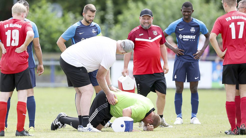 Schmerzhafter Moment kurz nach Spielbeginn: Ein Wolthuser Spieler schoss Schiedsrichter Bernd Eeten im Spiel gegen Münkeboe unabsichtlich voll in den Rücken. Nach einer Behandlungspause – Wolthusens Torwart-Trainer Georg Beyer eilte zur Hilfe – konnte der Schiri aber weitermachen. Fotos: Doden, Emden