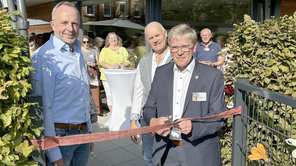 Der erste Vorsitzende des Trägervereins, Horst Feddermann (rechts), durchschnitt unter den wachsamen Augen von Schatzmeister (links) Detlef Meyer und Schriftführer Klaus Röttger das Band zum Gedenkgarten. Foto: Karin Böhmer