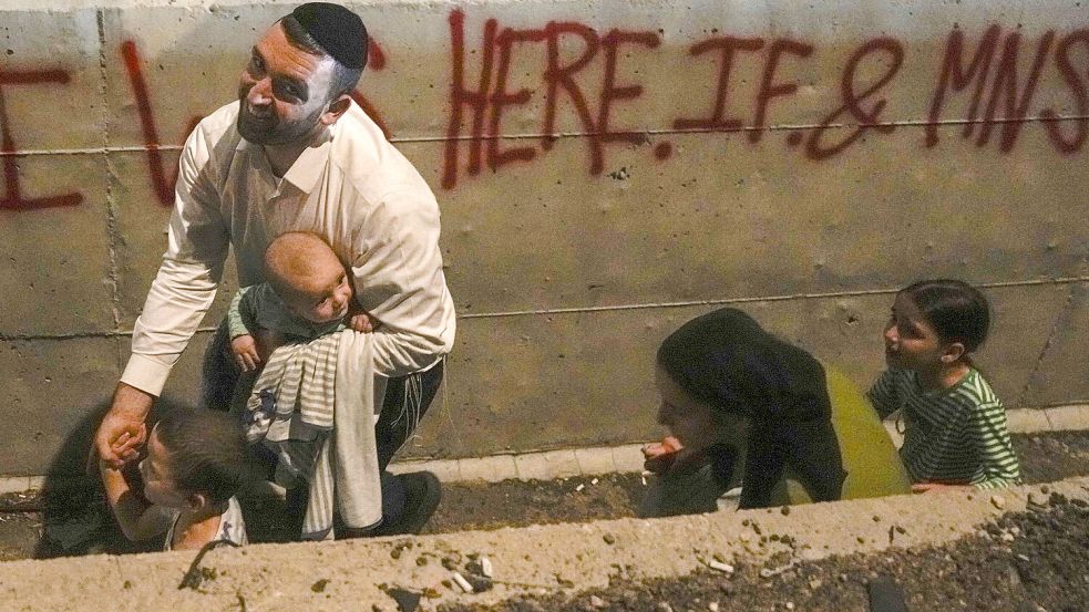 Raketenalarm in Shoresh: Ein israelischer Familienvater sucht mit seinen Kindern am Straßenrand Deckung. Foto: picture alliance/dpa/AP/Ohad Zwigenberg