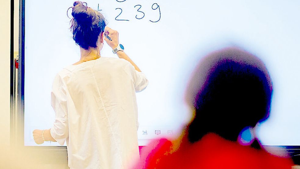 Eine Lehrerin schreibt eine Matheaufgabe auf: Wo brauchen Schulen am dringendsten finanzielle Unterstützung? Symbolfoto: Stratenschulte/dpa