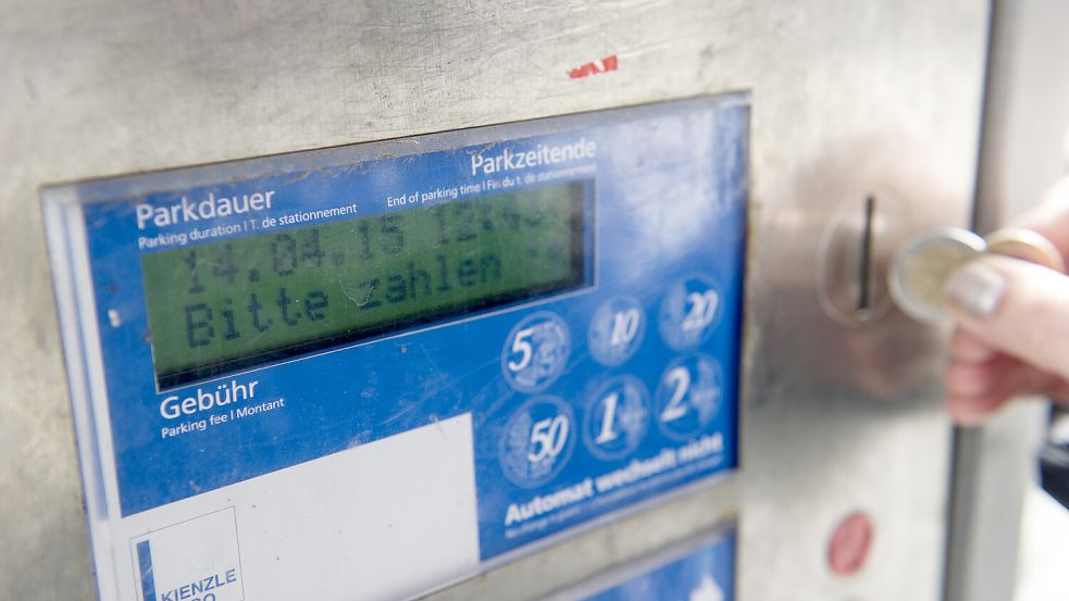Eine Frau zieht ein Parkticket. Symbolfoto: picture alliance/dpa