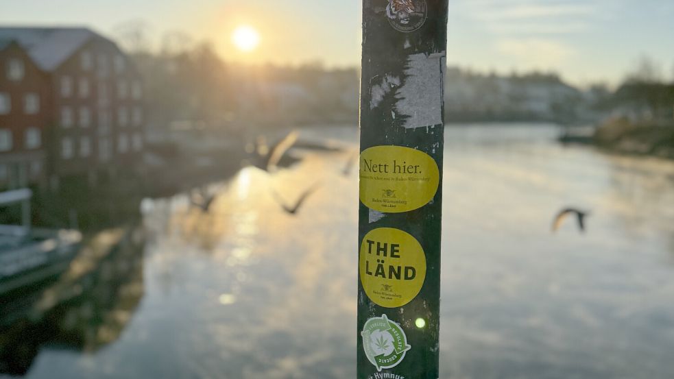 An einem Pfahl auf einer Brücke im norwegischen Trondheim kleben Aufkleber mit der Aufschrift „Nett hier“ und „The Länd“. Die Sticker sind Teil der Kampagne „The Länd“ des Landes Baden-Württemberg. Foto: dpa/Valentin Gensch