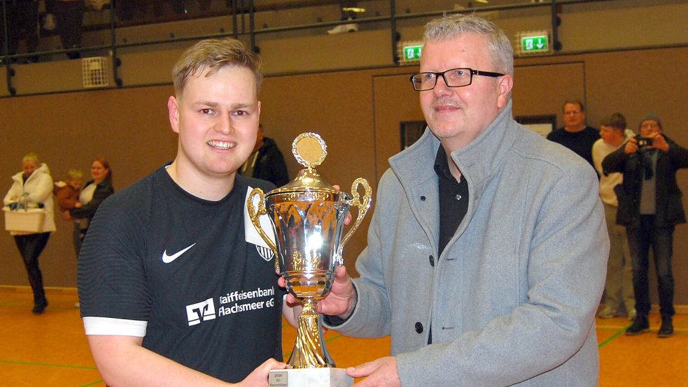 Bürgermeister Theo Douwes überreichte den Pokal an den Siegtorschützen Karsten Schulte. Foto: Reemts