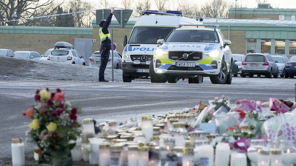 An einer Schule im schwedischen Örebro legten nach einem Attentat Menschen Kerzen und Blumen nieder. Foto: dpa/Sergei Grits