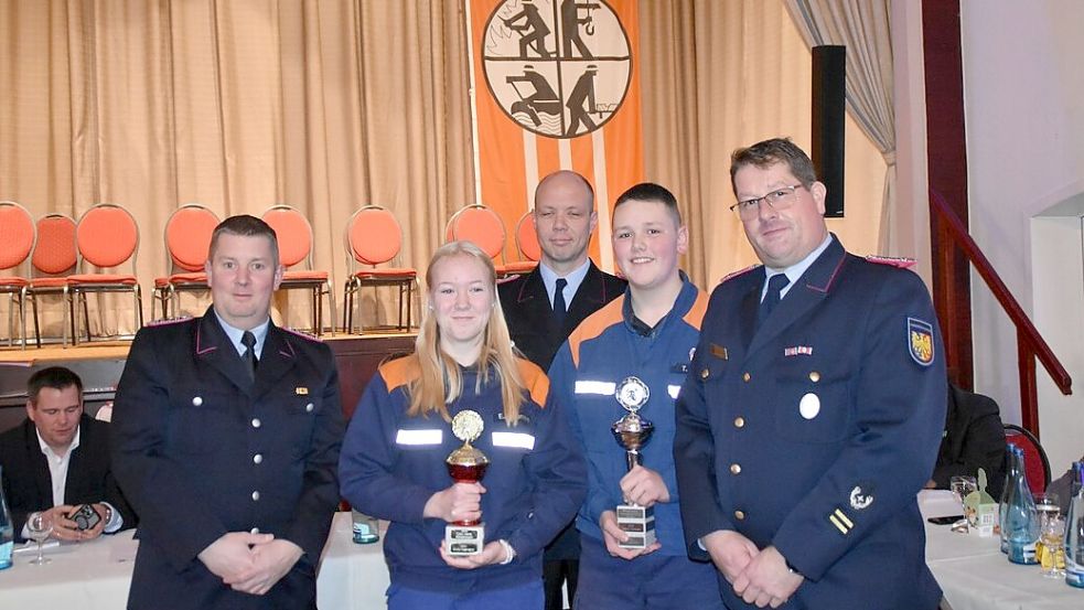 Emily Neemann und Til Schröder bekamen Wanderpokale für die meisten geleisteten Stunden in der Jugendfeuerwehr überreicht. Stadtjugendfeuerwehrwart Daniel Blankenhagen (links), Stadtbrandmeister Thomas Kettler (rechts) und dessen Stellvertreter Thomas Wege gratulierten. Foto: privat