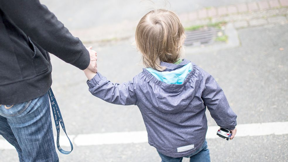 Eine Frau hält ein Kind an der Hand. In der Kinder- und Jugendhilfe entsteht ein immer größeres finanzielles Defizit. Symbolfoto: Marcel Kusch/dpa