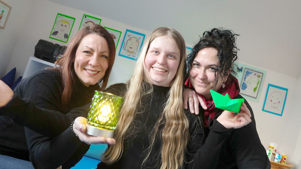 Ein starkes Team in schweren Zeiten: Familienbegleiterin Britta Baumann (links) mit Madlene und Mama Sabine Hattermann. In den Händen halten sie Gegenstände in der Farbe grün, mit der auf den „Tag der Kinderhospizarbeit“ aufmerksam gemacht wird. Foto: Romuald Banik