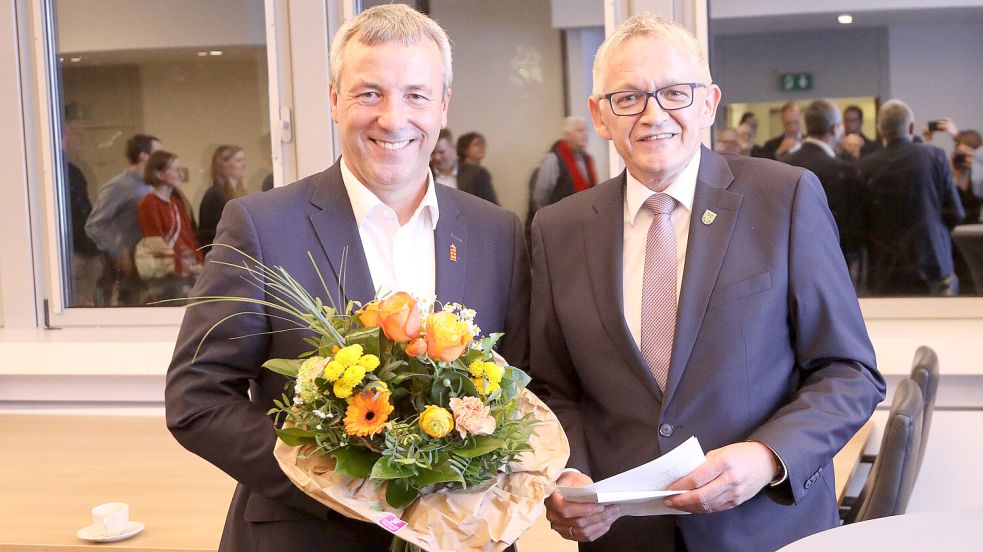 Der Auricher Landrat Olaf Meinen (rechts) gratulierte Johann Saathoff mit Blumen zum Wahlkreis-Sieg. Foto: Romuald Banik